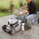How is the oil change in the lawn mower carried out?